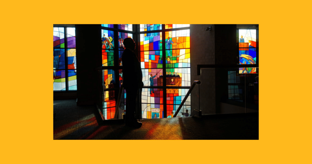 Henry Louis Gates silhouetted before stained glass window at Trinity UCC, Chicago